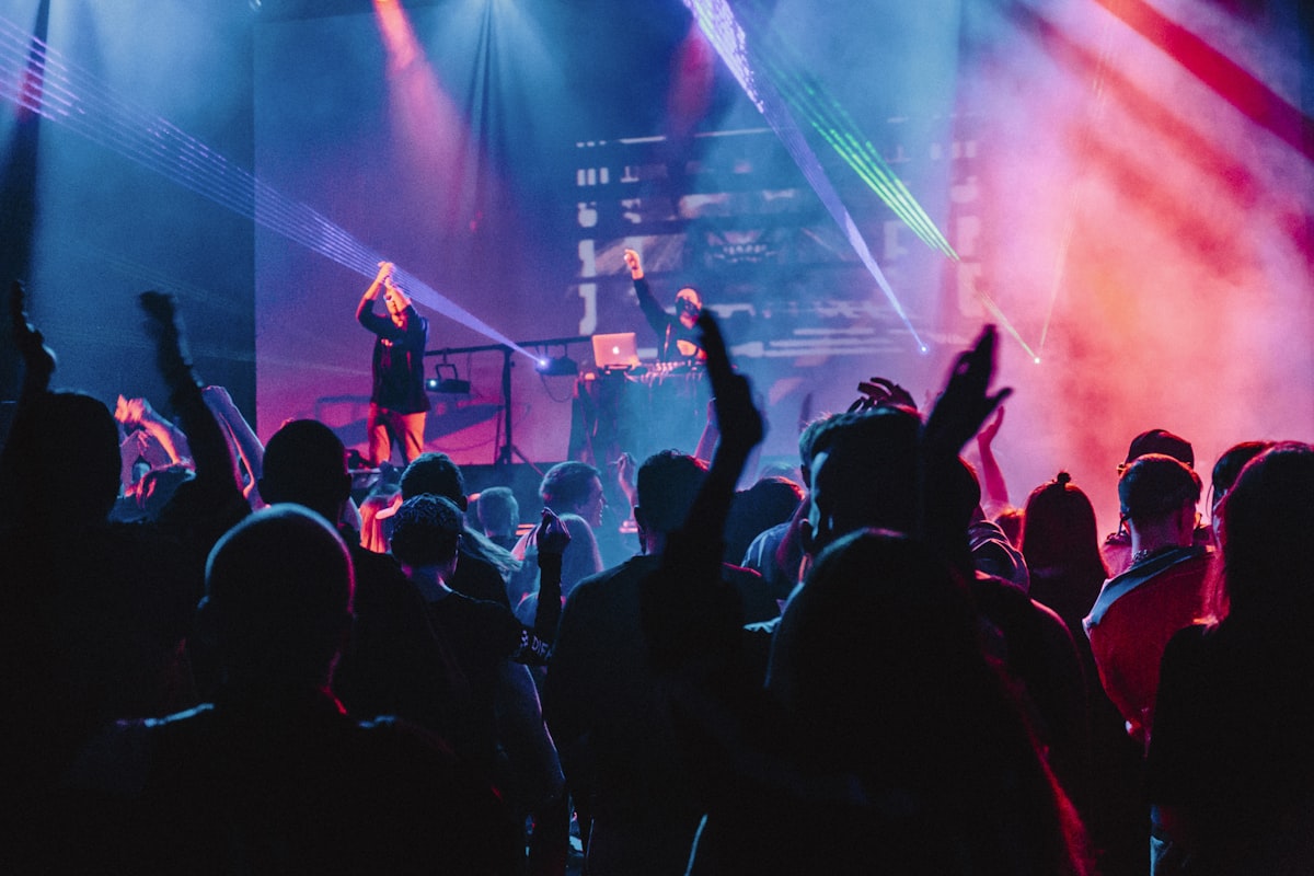 Crowd dancing at modern DJ set with lights