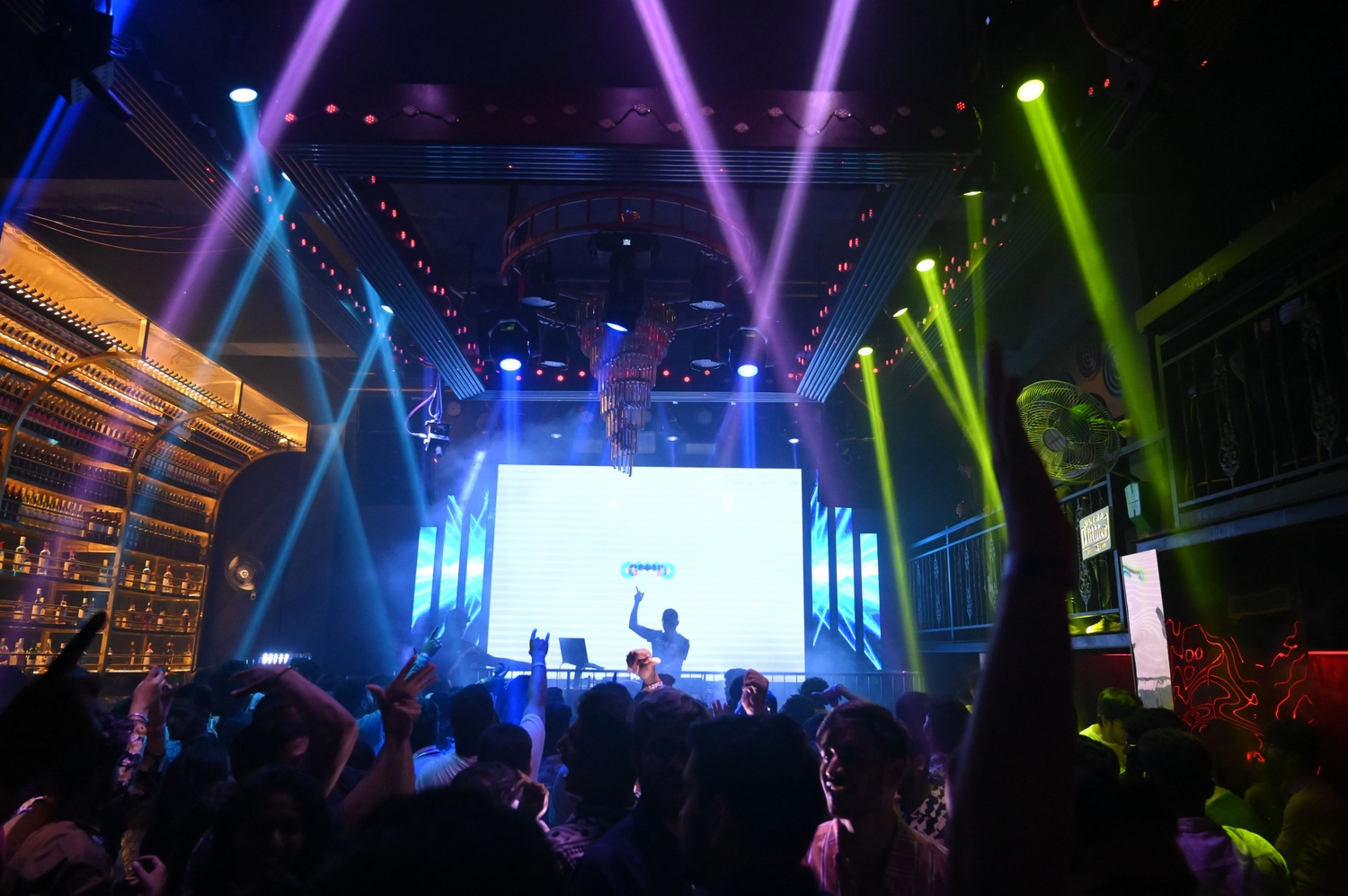 DJ VIC performing at a sangeet night with colourful lighting